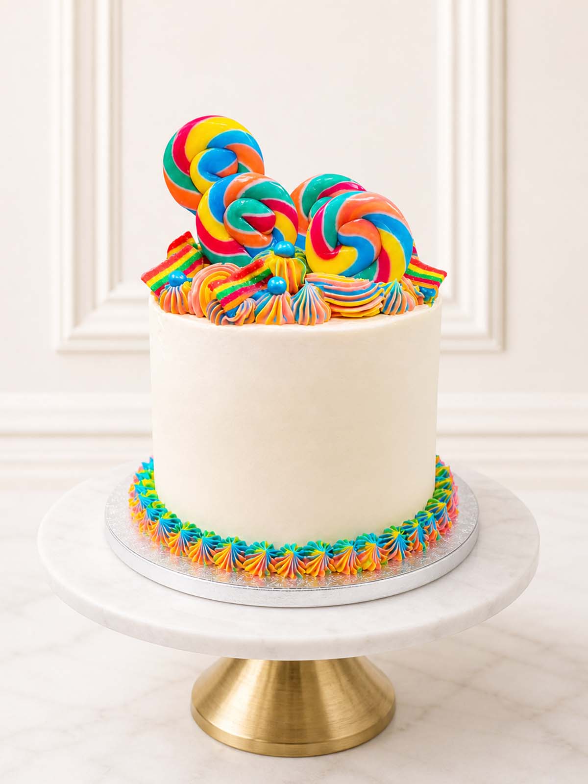 Luxury five-layer rainbow cake with lollipops and sprinkles, London and Surrey.