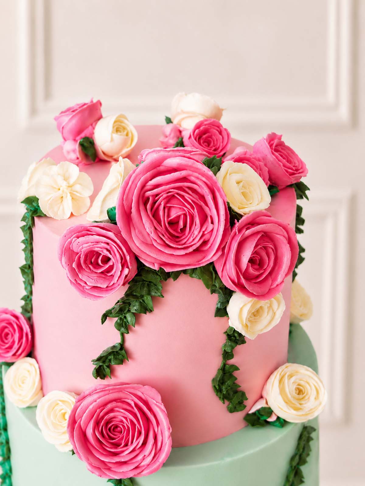 Pink and pastel green wedding cake decorated with pink and white roses handmade and delivered in London and Surrey. 