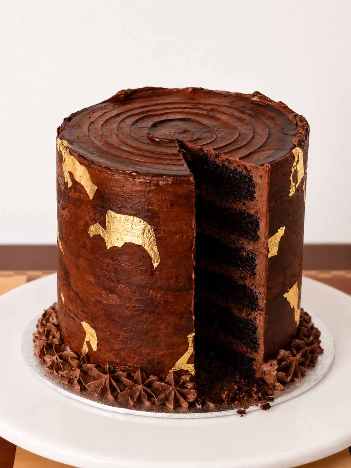 Chocolate Crunch Mile High Cake with a slice taken showing the interior of the cake. Same day and Next day