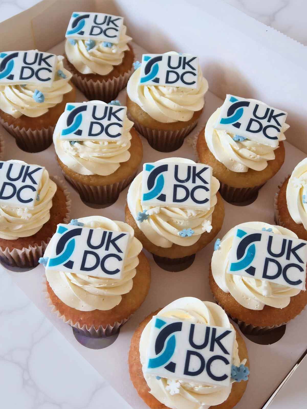 Corporate Cupcakes with UK DC logo on a white surface