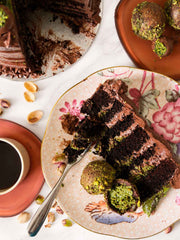Sliced dubai chocolate cake with green pistachio truffles handmade and delivered in London and Surrey.