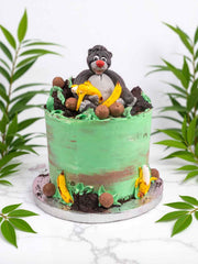 Jungle Book Baloo cake with green and brown icing, chocolate balls, and banana decorations