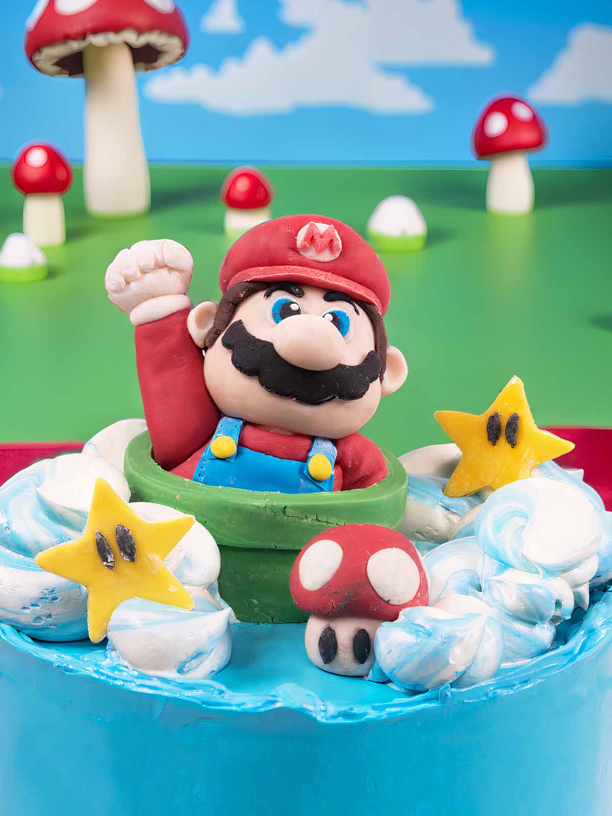 The Mario Cake features a fondant Mario in a green pipe, surrounded by star and mushroom decorations on blue icing—a perfect gaming birthday cake.