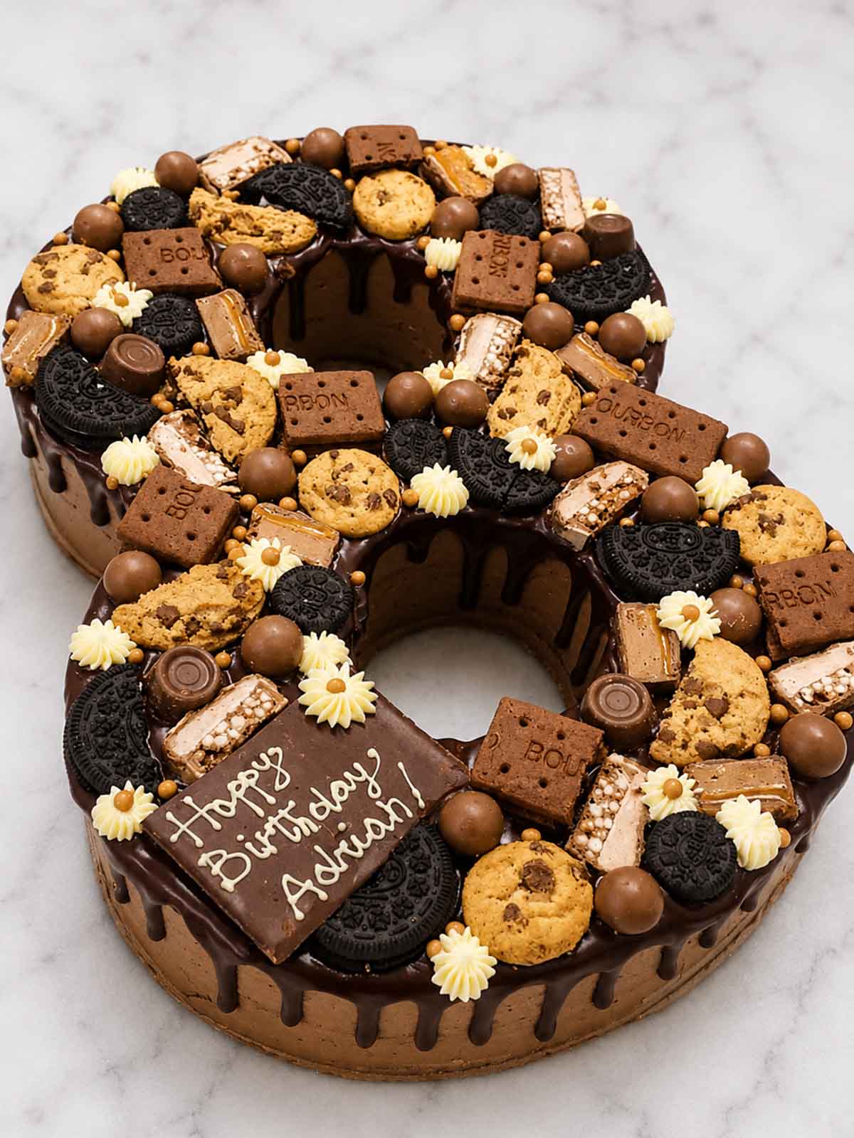 Birthday cake shaped like the number 8 with various cookies and a personalised message. 