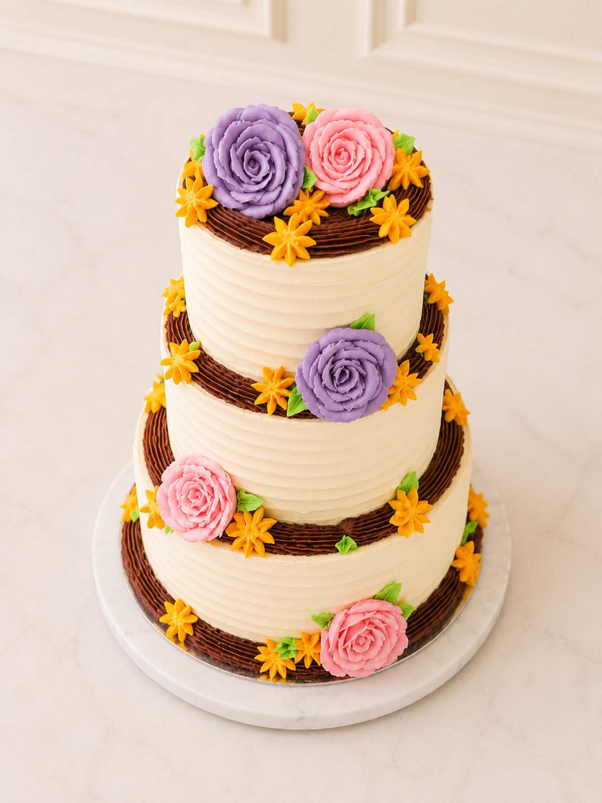 Three-tiered cake with floral decorations and a rustic aesthetic delivered in London and Surrey