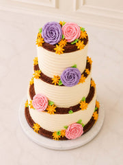 Three-tiered cake with floral decorations and a rustic aesthetic delivered in London and Surrey