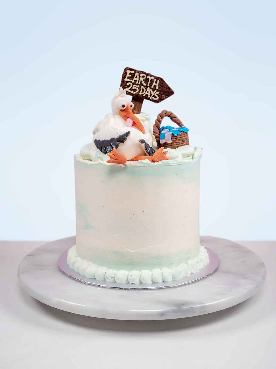 Stork baby shower cake with fondant stork, basket and buttercream clouds