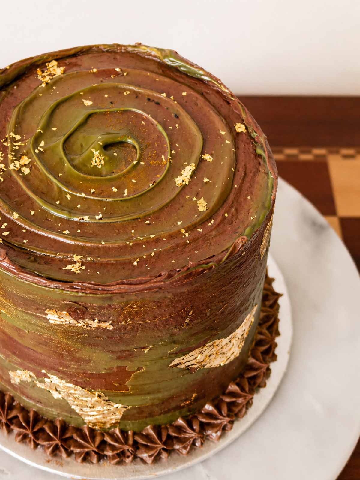 Top view of Chocolate Pistachio Crunch Cake with Gold Leaf