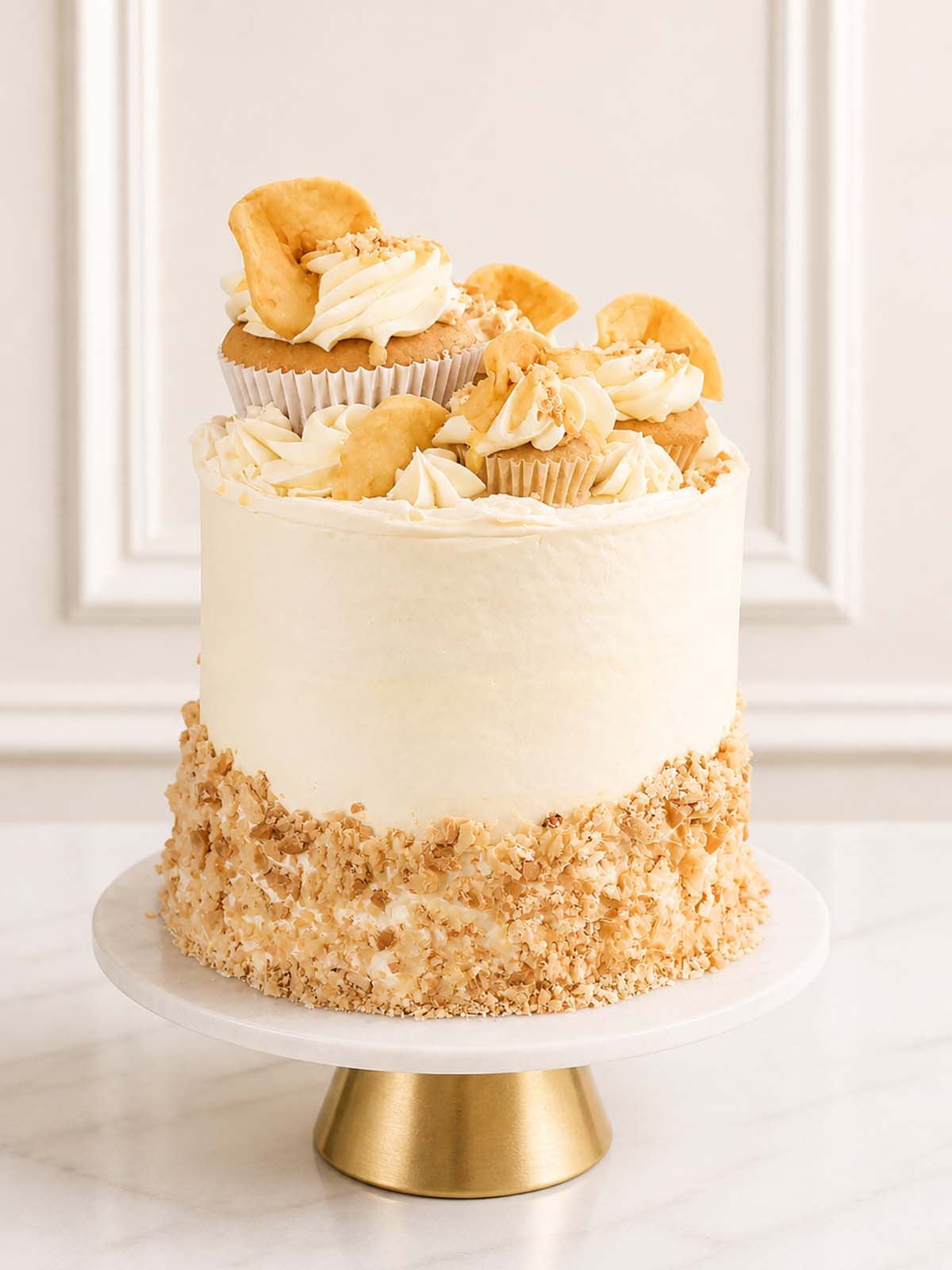 A cozy apple pie celebration cake featuring spiced cinnamon sponge, custard Swiss meringue buttercream, and a topping of golden pie crust crumble and cupcakes, delivered in London.
