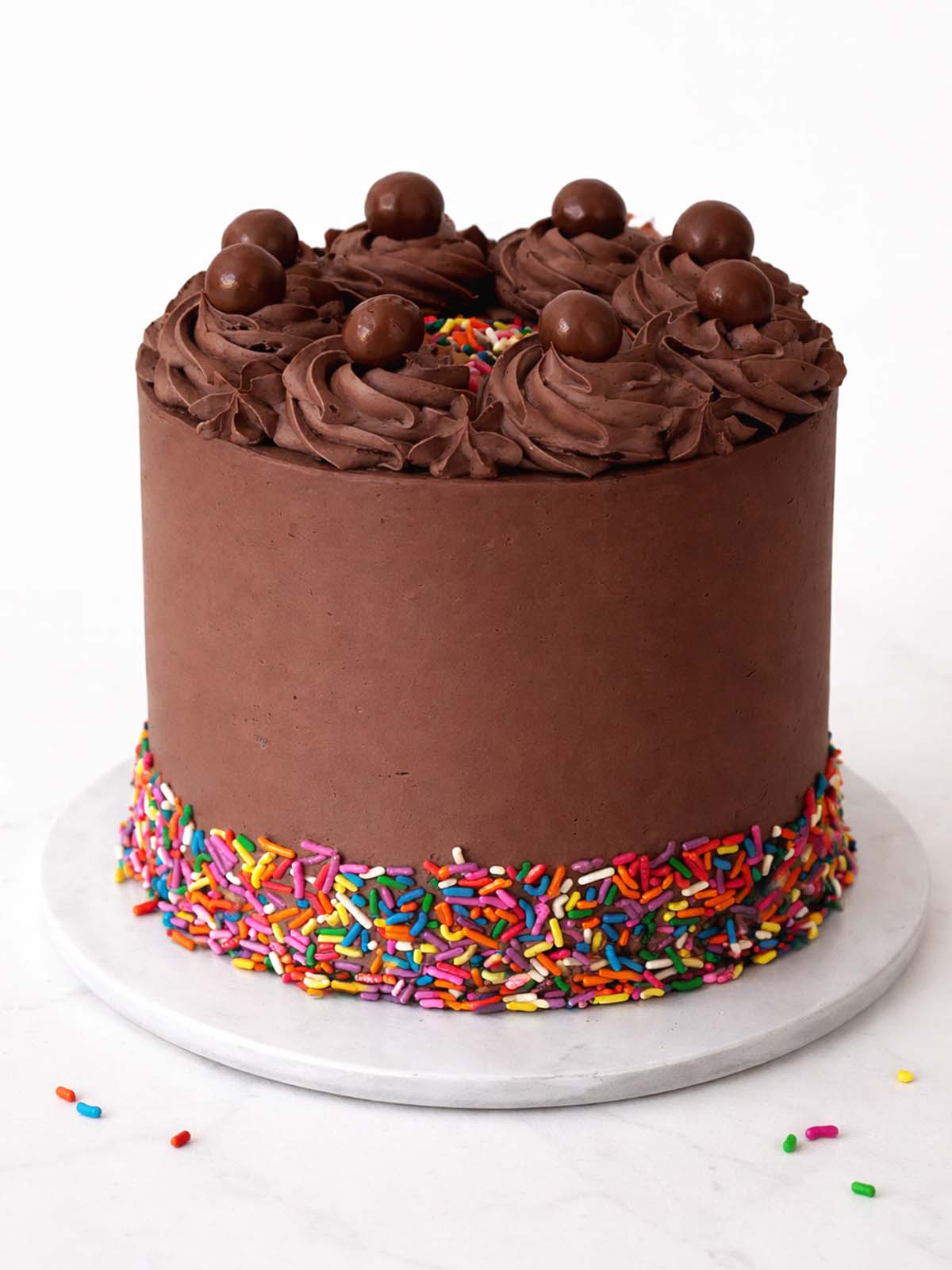 Chocolate rainbow birthday cake showing smooth chocolate buttercream finish, delivered in London