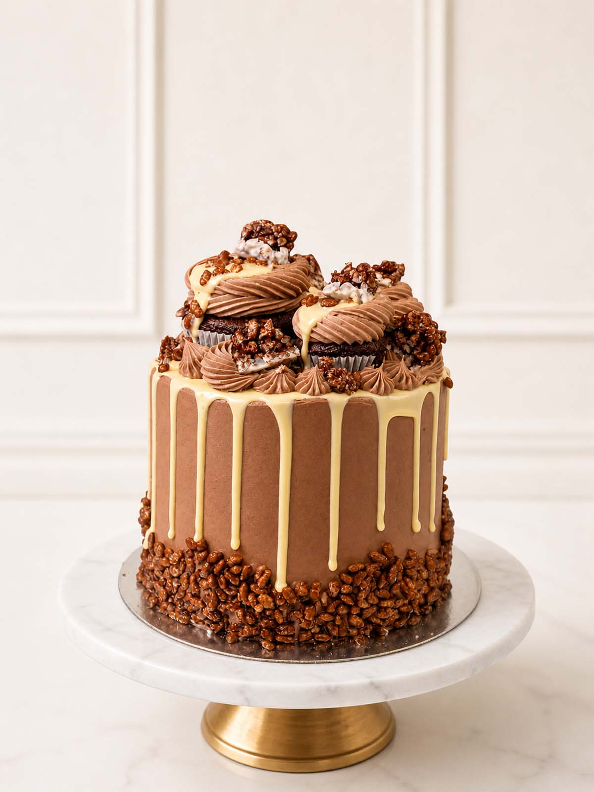 Nostalgic breakfast novelty cake featuring three layers of rich chocolate sponge, Belgian chocolate buttercream, white chocolate drip, and topped with crispy chocolate rice cereal and mini cupcakes. Delivered in London.