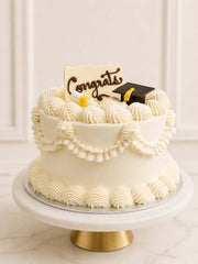 Elegant custom graduation cake featuring vintage retro Lambeth piping, an edible graduation cap, and a scroll cake topper. Available for delivery in London.