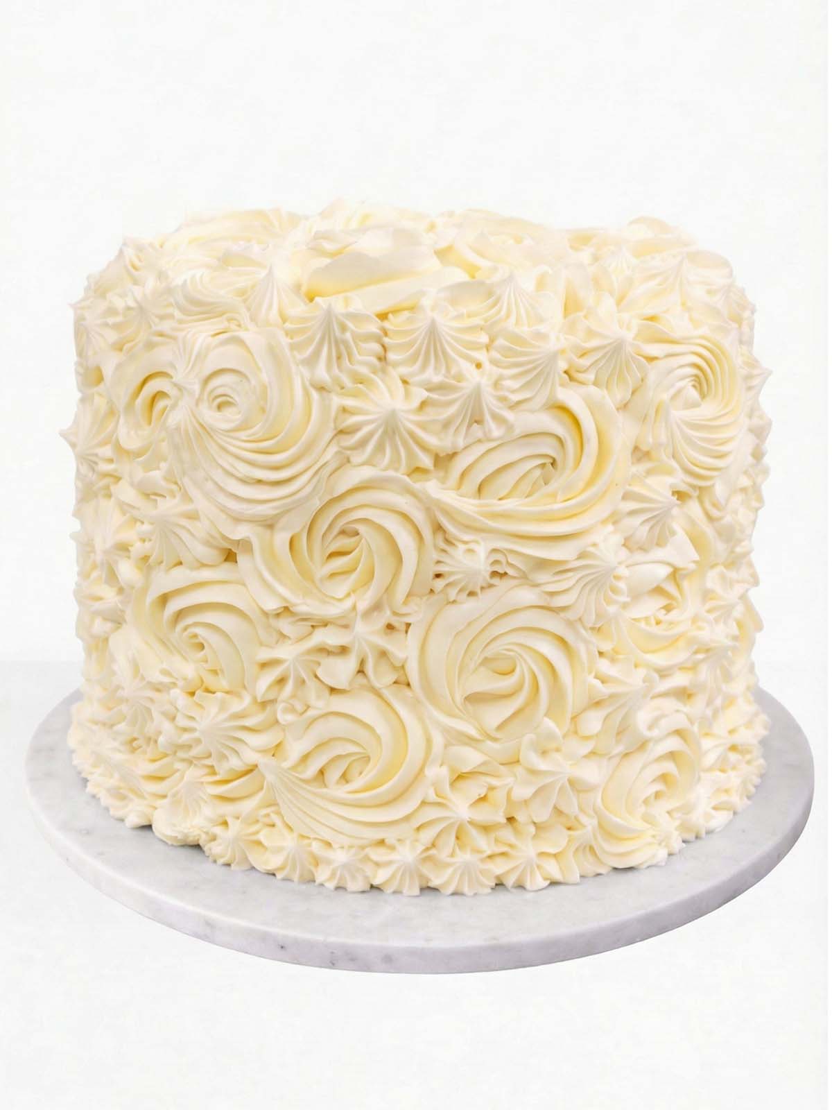 Five-layer vanilla rainbow birthday cake with colourful sponge layers and buttercream, delivered in London