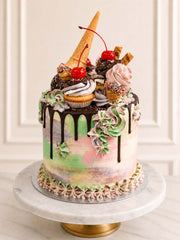 Ice cream parlour birthday cake with buttercream cones, cupcakes, sprinkles and chocolate drip.