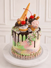 Side view of the ice cream themed sponge cake with cones and glacé cherries.