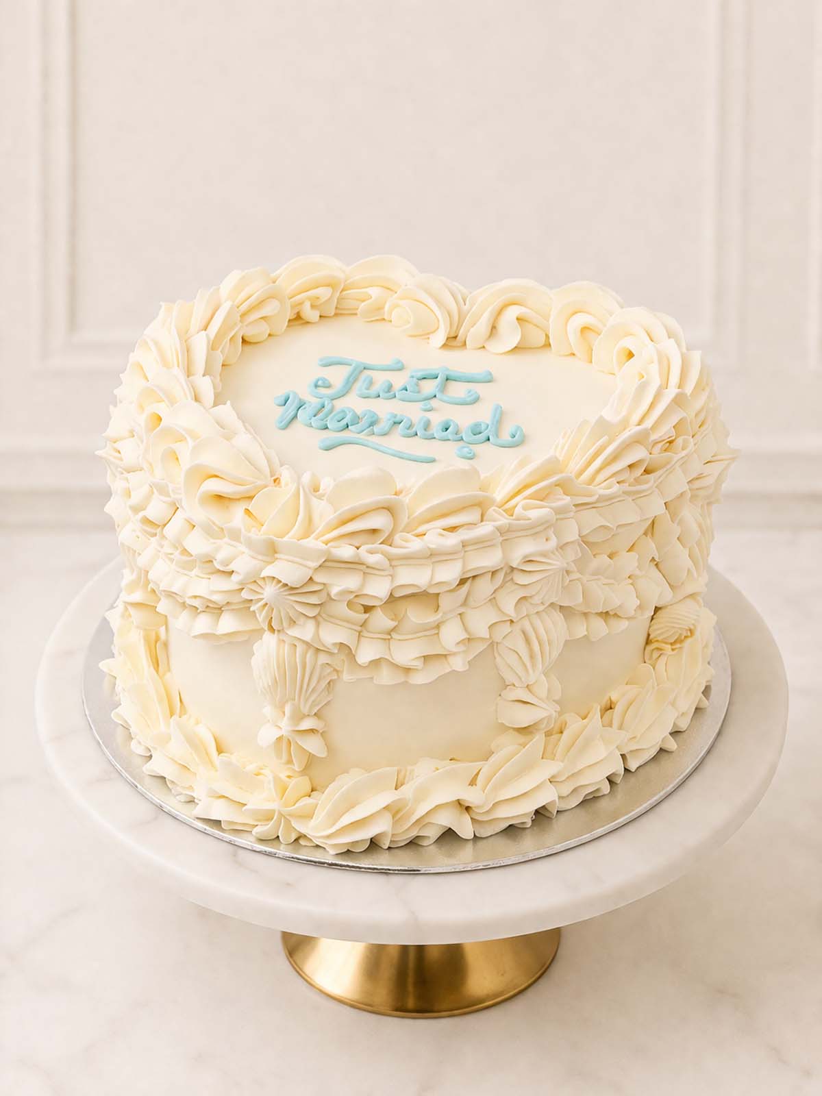 Two-layer fluffy vanilla sponge heart cake, perfect for civil ceremonies and micro-weddings, decorated with customisable vintage buttercream swirls. Delivered across Surrey.