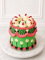 Close angled view of the Kitsch Chicken Cake decorated with hand-piped chickens, pink ruffles, blossoms and criss-cross piping.