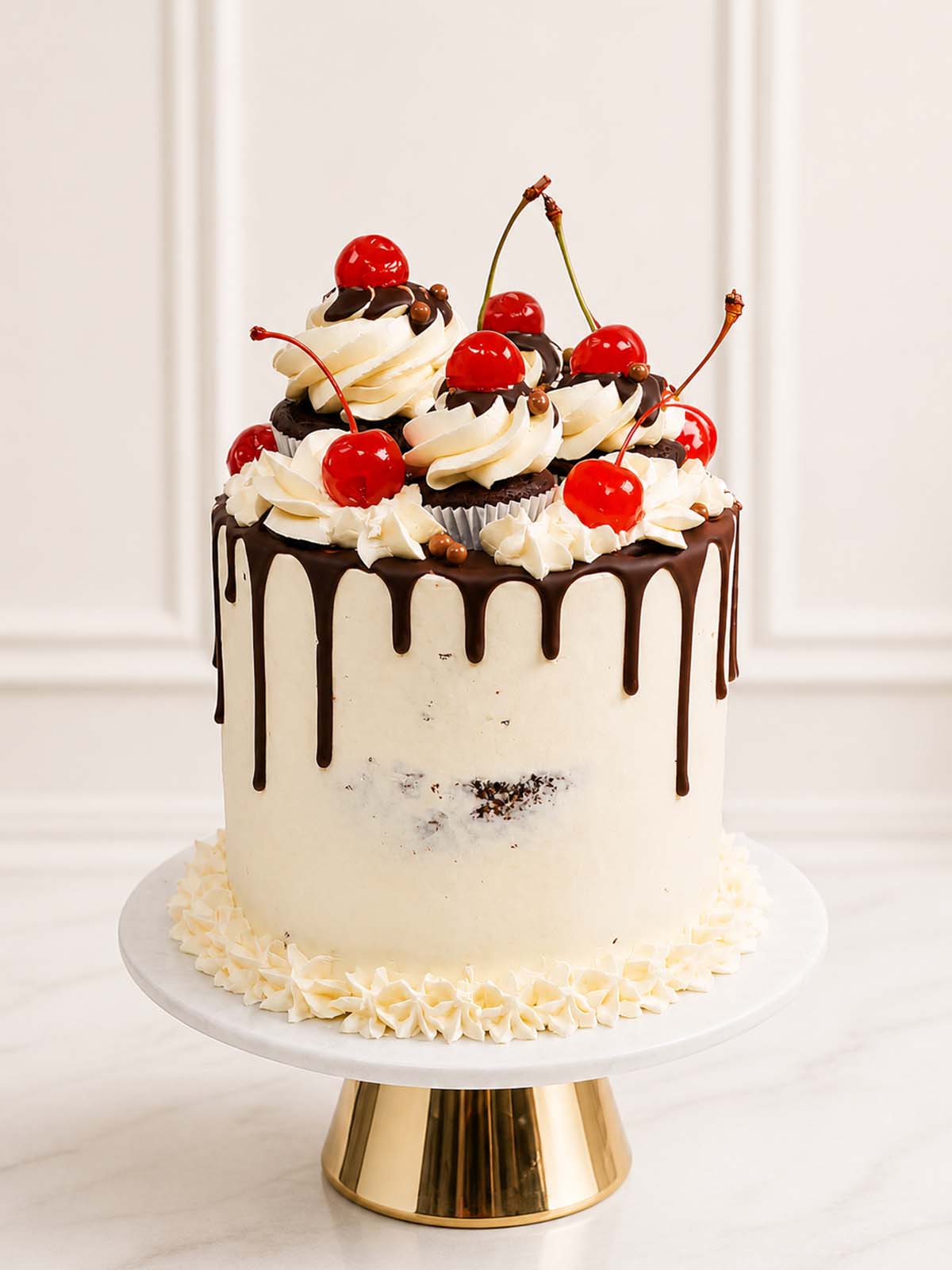 A luxury Black Forest celebration cake featuring cocoa-rich chocolate sponge, tangy cherry filling, and cream cheese frosting topped with elegant mini cupcakes, whipped cream, and cherry crowns, delivered in London.