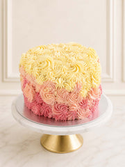 An elegant pink ombre heart-shaped cake featuring layers of rich red velvet sponge and artistically piped vanilla Swiss meringue buttercream, delivered in London and Surrey.