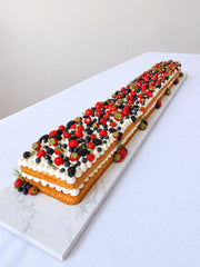 Close view of Victoria Sponge Table Runner Cake with buttercream and mixed berries