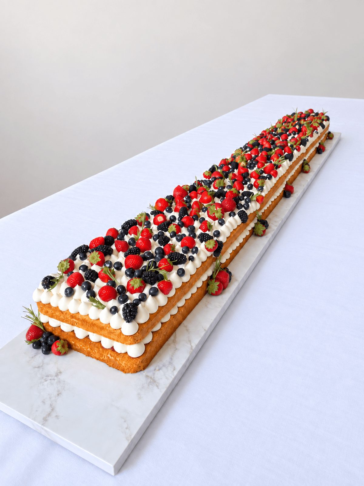 Close view of Victoria Sponge Table Runner Cake with buttercream and mixed berries