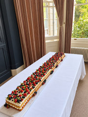 Full-length two-metre Victoria Sponge Table Runner Cake arranged along a table