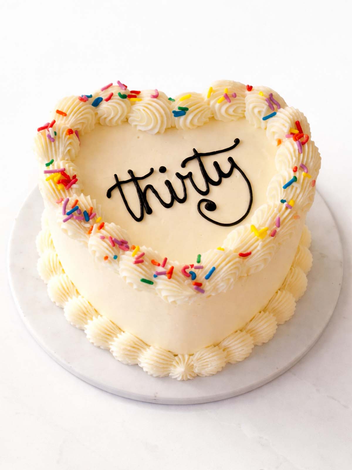 Vintage heart-shaped birthday cake with piped buttercream and retro detailing, delivered in London