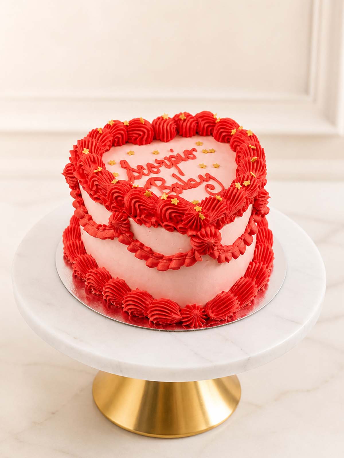 A retro vintage Lambeth-style heart-shaped birthday cake featuring intricate pink and red Swiss meringue buttercream piping, golden sprinkles, and a hand-piped "zodiac Baby" message. Delivered across London and Surrey.