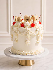 A nostalgic Victoria sponge celebration cake featuring golden layers, strawberry jam, and vanilla buttercream topped with vibrant cherries and heart-shaped jam biscuits, delivered in London and Surrey.